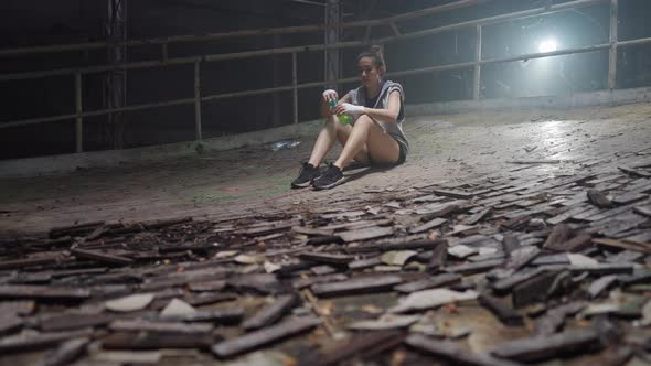 4K Asian woman drinking sports drink after do sport training in abandoned building.