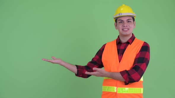 Happy Young Multi Ethnic Man Construction Worker Talking While Showing Something