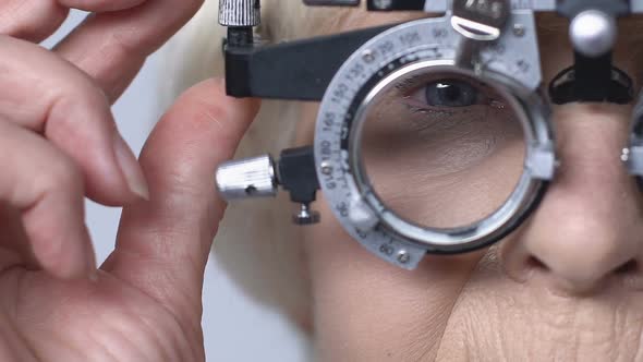 Female Pensioner Checking Vision Through Phoropter