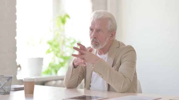 Pensive Old Man Thinking While Sitting in Office