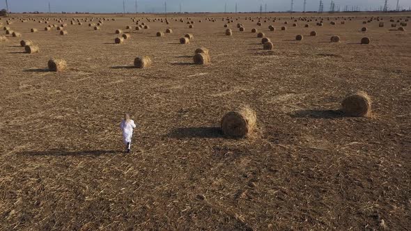 a girl in white runs across the field