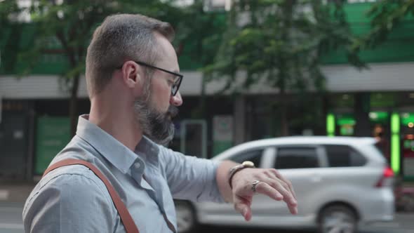 Handsome American man wearing glasses confidence standing and looking watch.