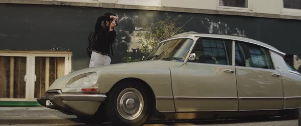 Caucasian man taking pictures of a vintage car