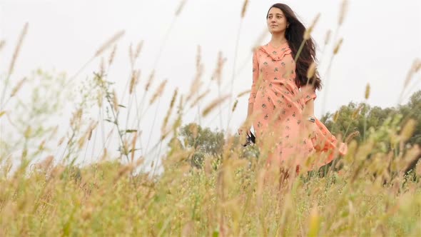 Beautiful Girl Walks in the Field