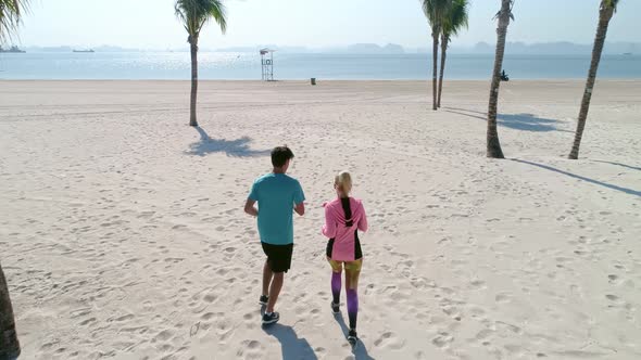 Drone view of couple starting up their jogging training. Shot with RED helium camera in 8K