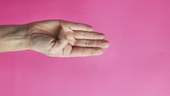 Gesture of Violence of Women on a Pink Background