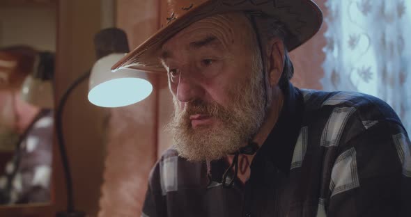 Portrait of Lonely Thoughtful Senior Man Sitting in Room