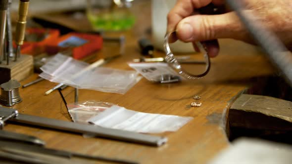 Goldsmith working at desk in workshop