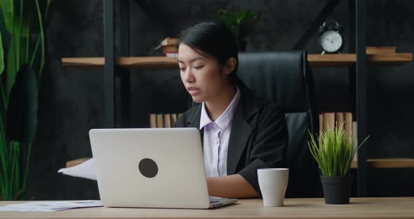 Asian Business Woman Video Chatting with Laptop at Office