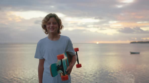 Silhouette Happy Child Portrait of Young Stylish Skater Boy Holding His Skateboard Outdoors