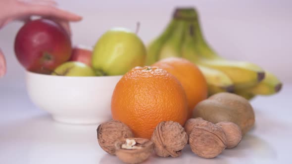 Girl Lays Fruits and Nuts on the Table With Slow Motion