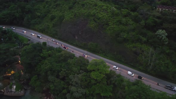 Heavy traffic on way down to beach at sunset, Brazil. Aerial pan right, high angle