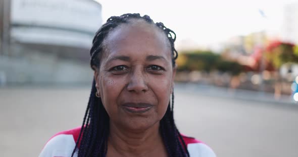 African senior woman smiling with city in the background