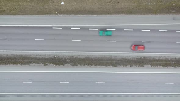 Aerial top down view of a road with fast moving traffic cars.