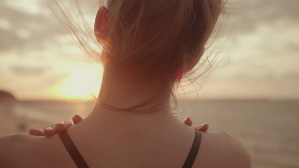 The Girl Stands with Her Back and Looks at the Beautiful Sunset