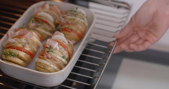 Chef Pushes Raw Dish with Potato and Meat Into the Oven