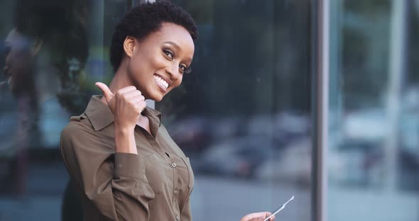 Active Mixed Race Businesswoman Waiting for Air Plane at Airport Terminal, Rejoices Sitting Outdoors