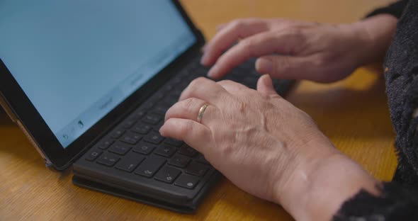 Woman typing a report on her tablet with a keyboard