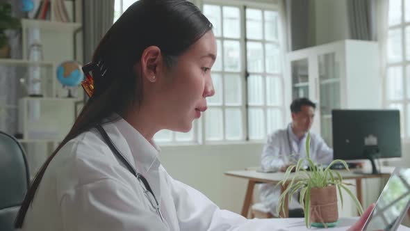 Close Up Asian Woman Doctor Having Video Conference On Tablet Computer In Workplace With Patient