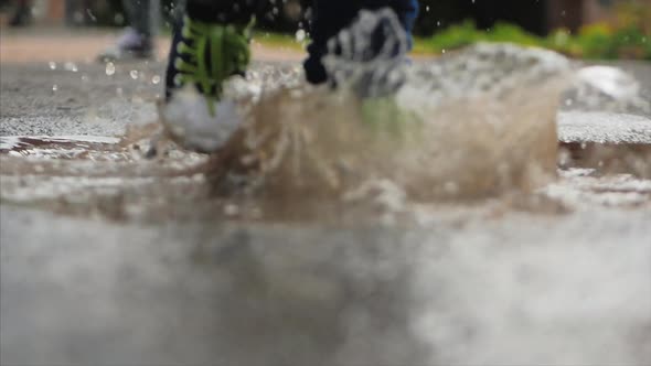 Close-up, Low Angle, Unrecognizable Kids Running Through Puddles Summer Day After Rain