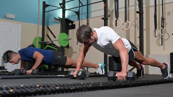 Two Strong Men Doing Pushups in Gym