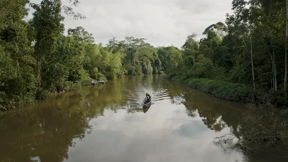 4k aerial shot of drone moving with the sailing boat in the Amazon river and tropical forest in both