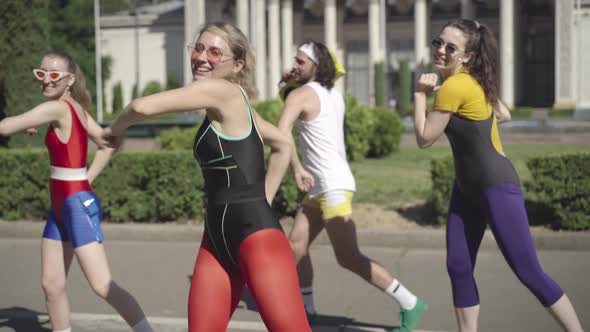 Portrait of Cheerful Female Fitness Instructor in Red Legging and Black Top Smiling As Dancing To