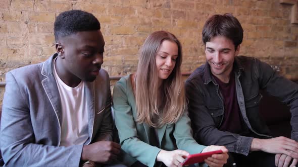 Happy friends having fun at bar and looking at smartphone