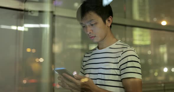 Young man use of mobile phone in the city 