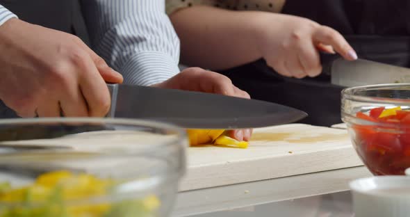 Close Up of Man and Woman Cooking Together Cutting Vegetables in Kitchen