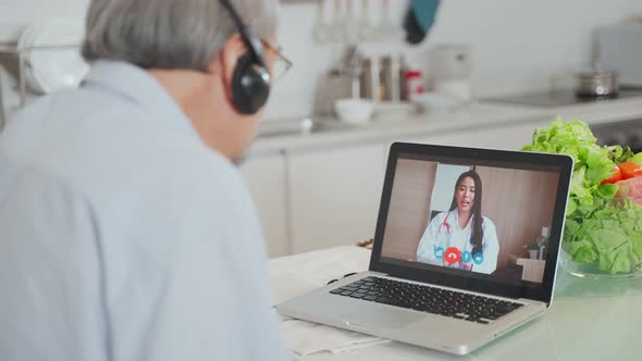 Asian senior older man grandmother use laptop video call with doctor in living room at home.