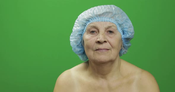 Smiling Elderly Female Lady in Protective Hat Scared of Syringe with Medicines