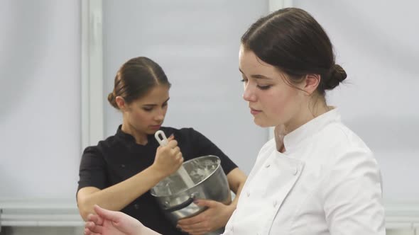 Young Attractive Female Chef Smiling to the Camera While Cooking