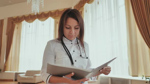 Girl Doctor Walking in Hospital with Documents