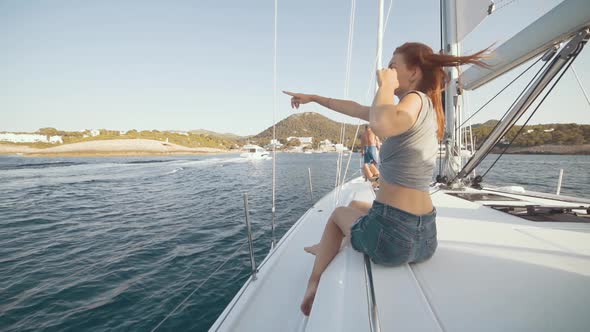 Beautiful Woman on a Yacht Enjoys the Journey on the Background of the Islands of Ibiza or Mallorca