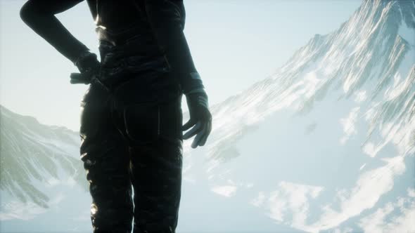 Woman Standing In Snow Wearing Warm Clothes In Mountains alt