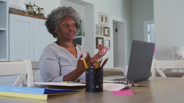 Senior african american woman having a video chat on laptop at home