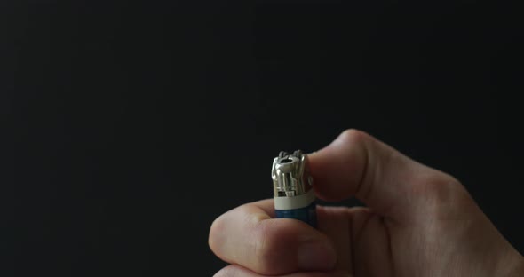 Lighting a lighter with a flame on a dark background