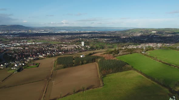 Aerial flyover of east Belfast from the countryside looking towards the city centre or center