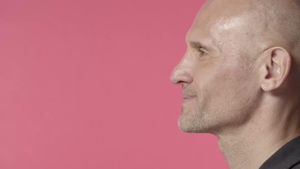 Profile Headshot of Middleaged Bald Man with Bristle Look Left at Blank Pink Copy Space Start Smile