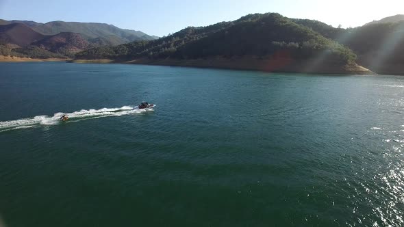 A nice summer day out on the lake enjoying some watersports with boats and personal watercraft.