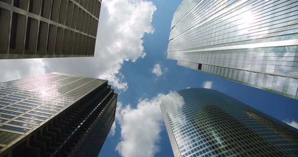 Looking Up at Business Skyscrapers Buildings in Dowmtown, Clouds Rolling in Sky and Reflections on