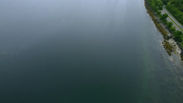 Blue, clear water and coastline of island revealed through clouds