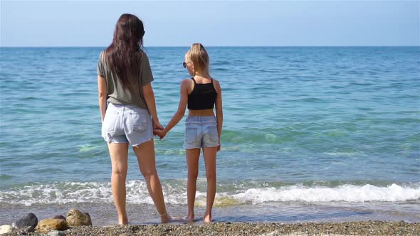 Beautiful Mother and Daughter on the Beach Enjoying Summer Vacation