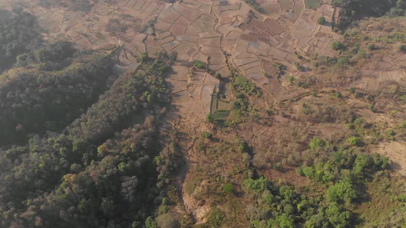 Pan down drone shot of expansive rural Indian farmland