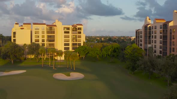 Aerial on a golf course passing a condominium cost by at a high rate of speed