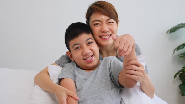 Asian mother caring for disabled son while living together at home