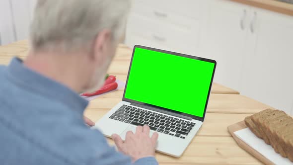 Rear View of Old Man Looking at Laptop with Chroma Key Screen