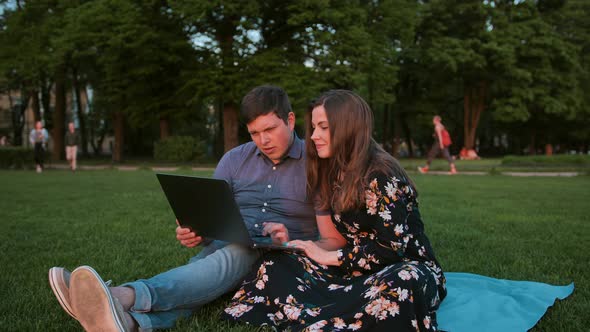 A Young Couple Is Surfing Internet in the Park