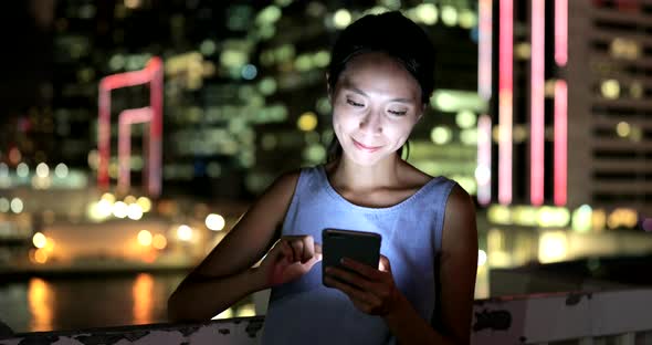 Woman using mobile phone in city 